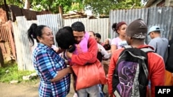 Marlon Brando Díaz (C-R), encarcelado por su participación en las protestas antigubernamentales de julio de 2021, saluda a sus familiares tras salir de prisión en el barrio Güinera de La Habana, el 16 de enero de 2025.